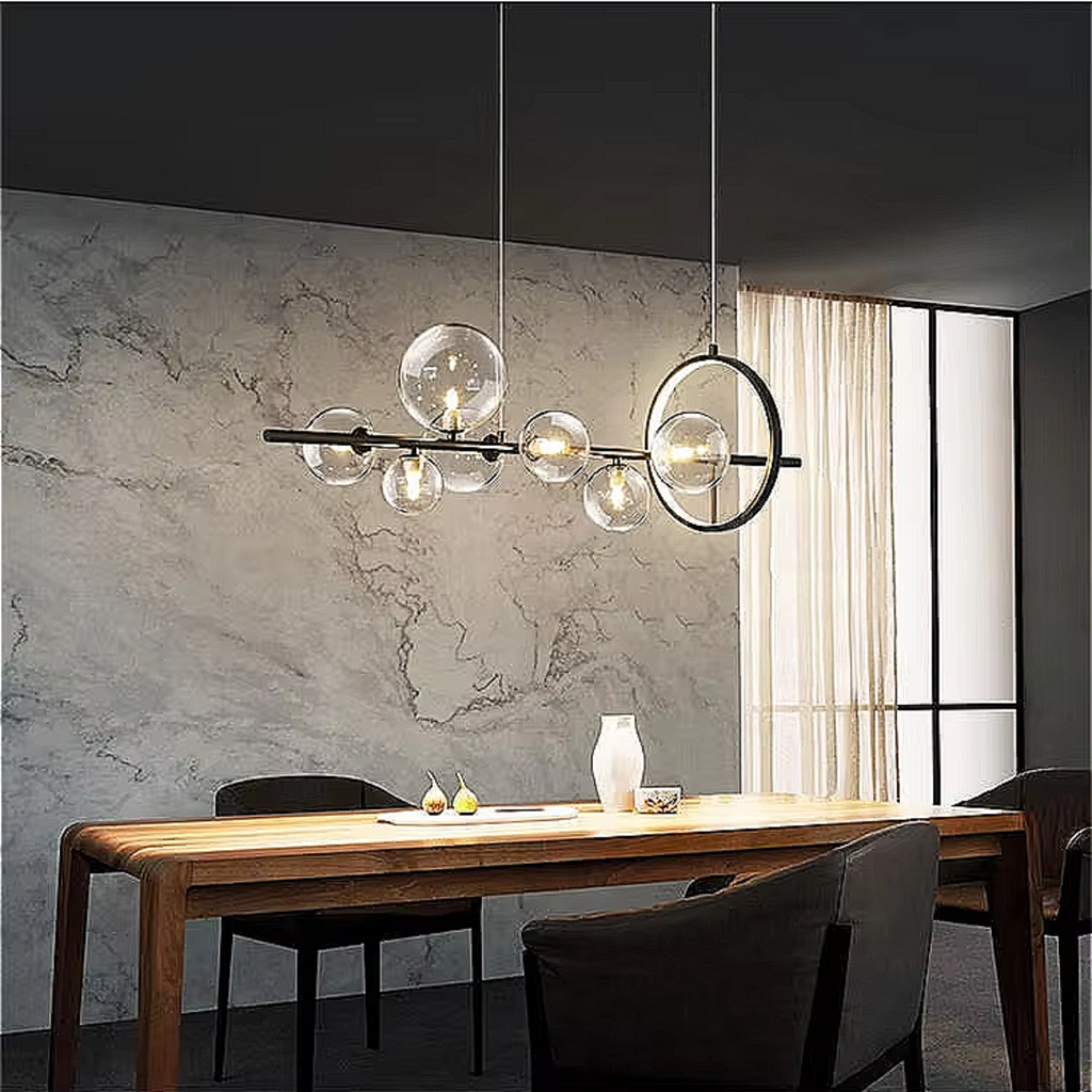 Modern-meets-vintage dining area illuminated by a sculptural black chandelier with glowing glass orbs, creating soft 3000K warmth above a styled table.