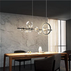 Modern-meets-vintage dining area illuminated by a sculptural black chandelier with glowing glass orbs, creating soft 3000K warmth above a styled table.