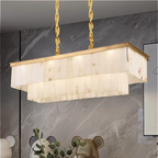 Marble chandelier with gold frame mounted in a modern luxury living room with grey stone walls and elegant trim detailing.