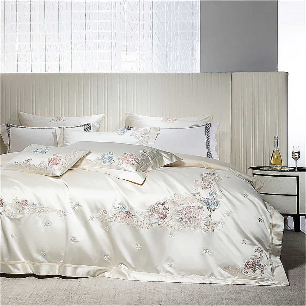Romantic floral bedding set featuring hand-embroidered blush and powder blue flowers on cream satin cotton