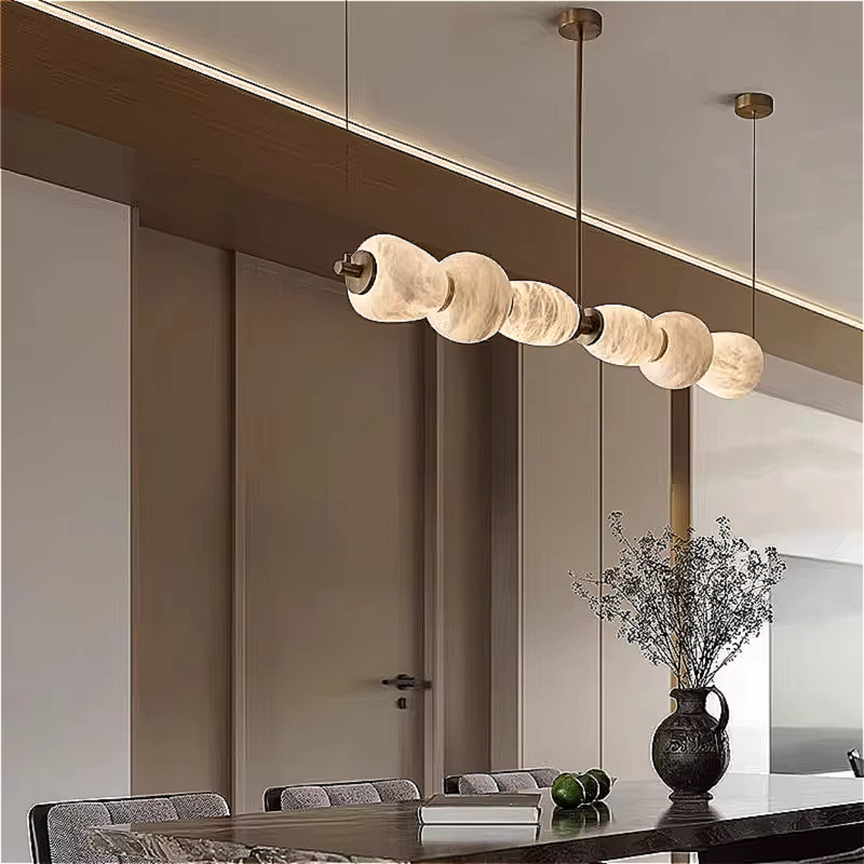Modern alabaster pebble chandelier above dining table with sculptural linear pendant design and warm architectural glow – LINKORI MARSH MARBLE
