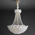 Grey-toned luxury living room illuminated by a floral chandelier, highlighting detailed craftsmanship with a close-up of textured petals and golden lighting.