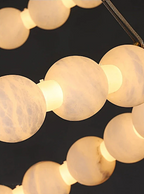 Alabaster stone orb chandelier glowing warm light through natural veining – organic modern luxury pendant light detail | LINKORI AURELIA