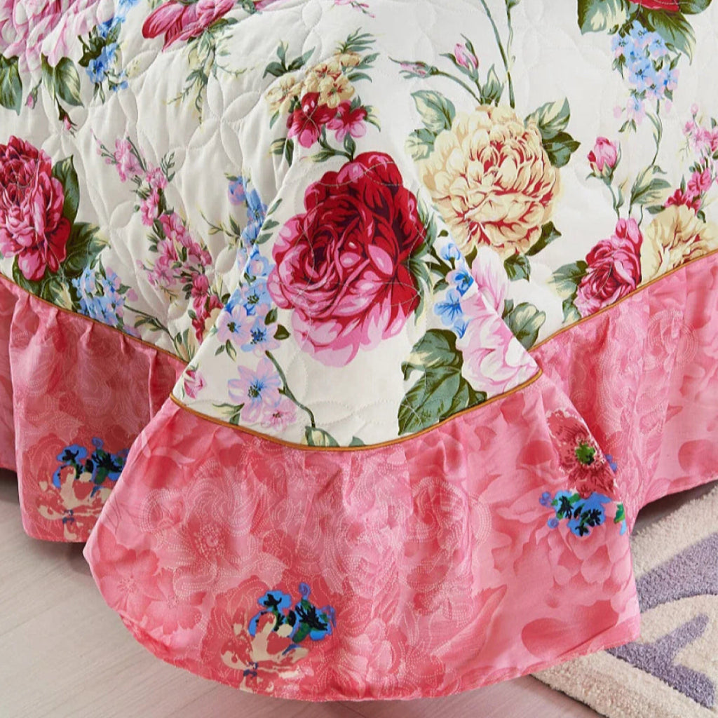 Floral quilted bed spread with pink ruffled edge in the cottagecore bedroom