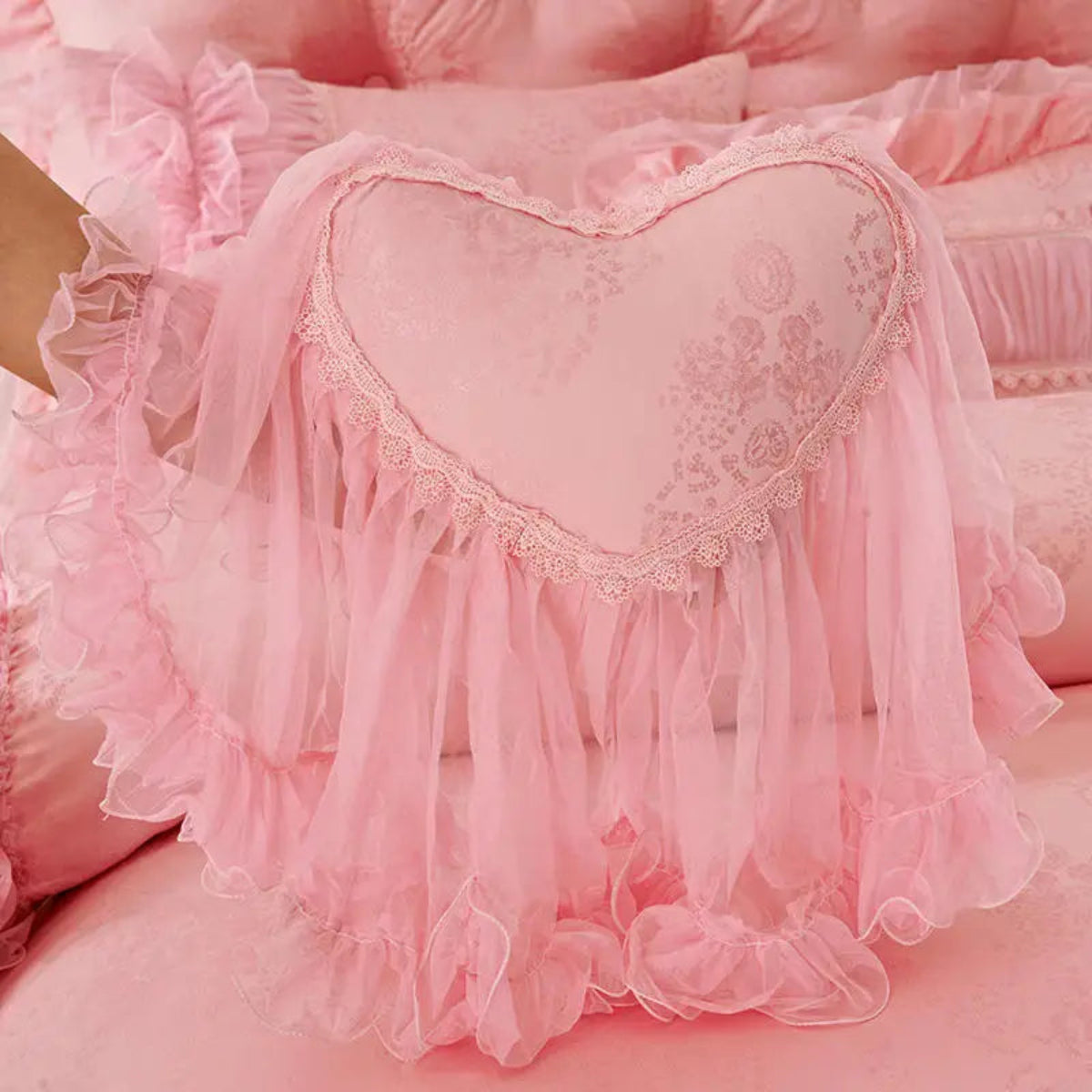 Heart-shaped lace pillow with full lace edging on pink ruffle bedding — tatting lace, cottagecore bridal accent for romantic bedrooms | LINKORI Lacelet Pink heart pillow view