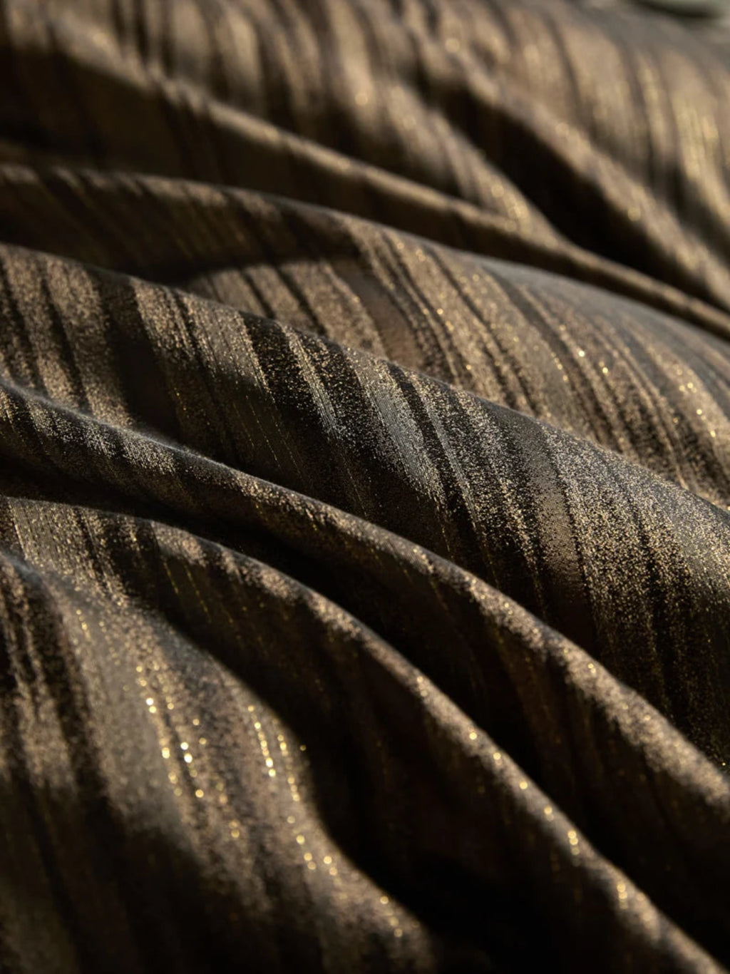 Luxury shiny satin bedding set with brown & gold stripes styled in modern glam bedroom