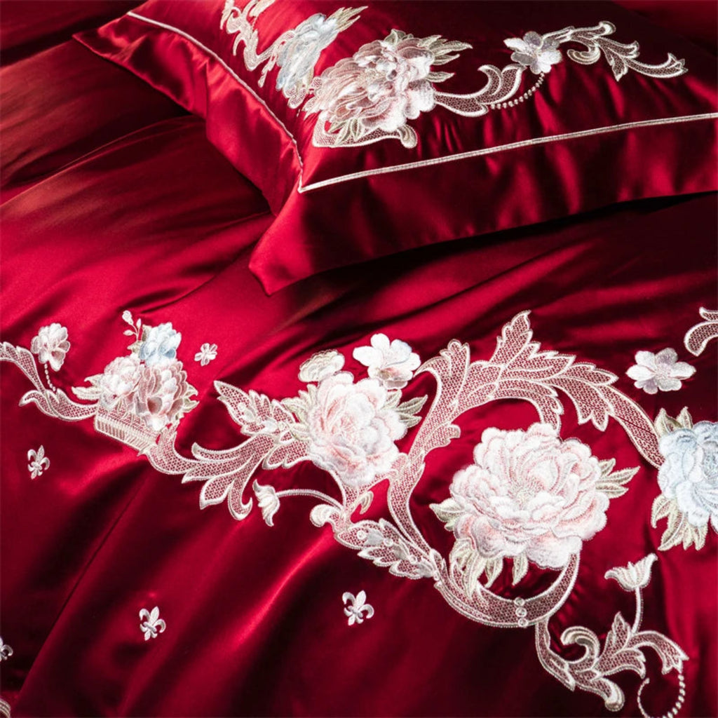 Dramatic red satin bedding set featuring hand-embroidered flowers for luxurious bedroom transformation