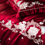 Dramatic red satin bedding set featuring hand-embroidered flowers for luxurious bedroom transformation