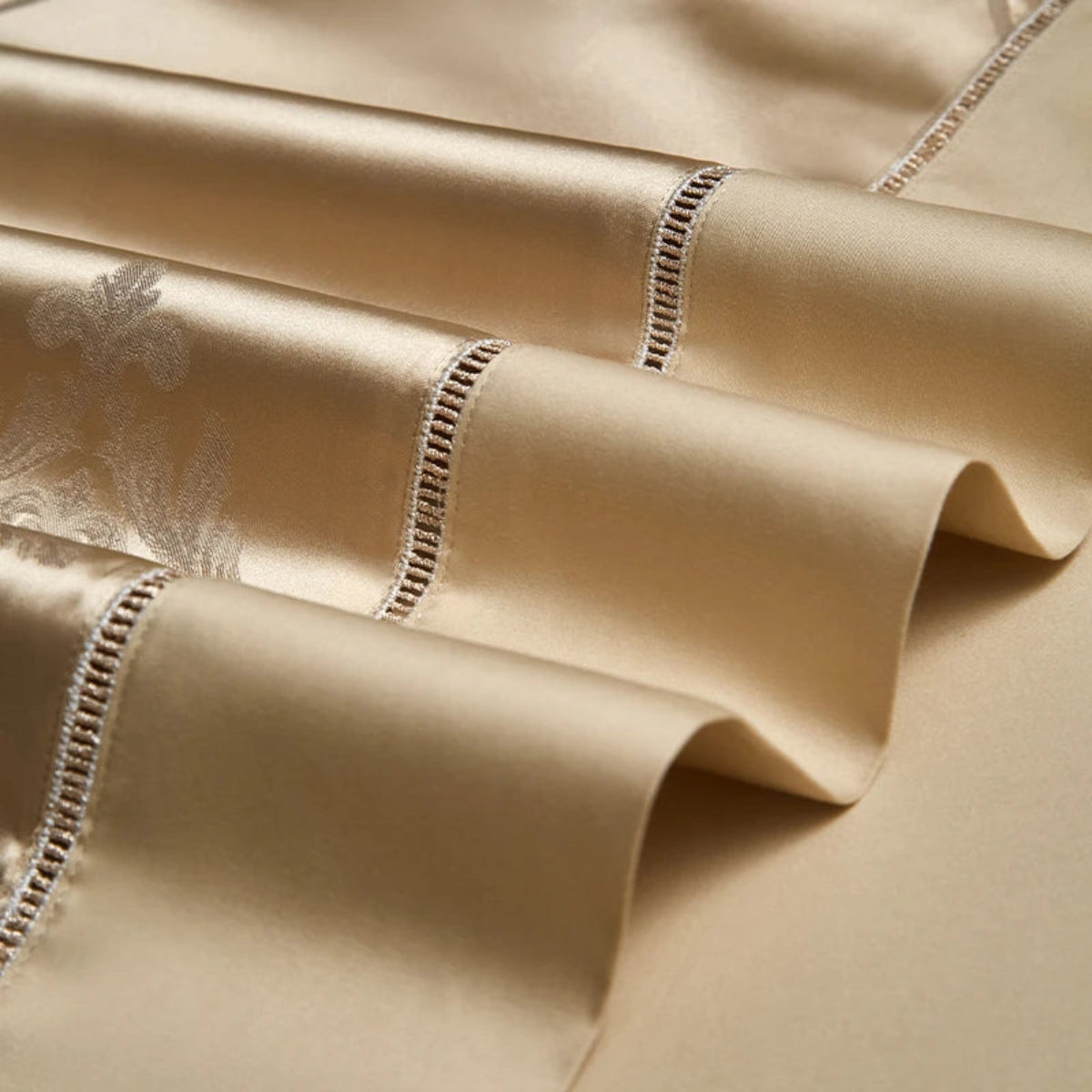 Champagne gold Egyptian cotton satin bedding with luxurious geometric jacquard textures and coordinating trim borders.