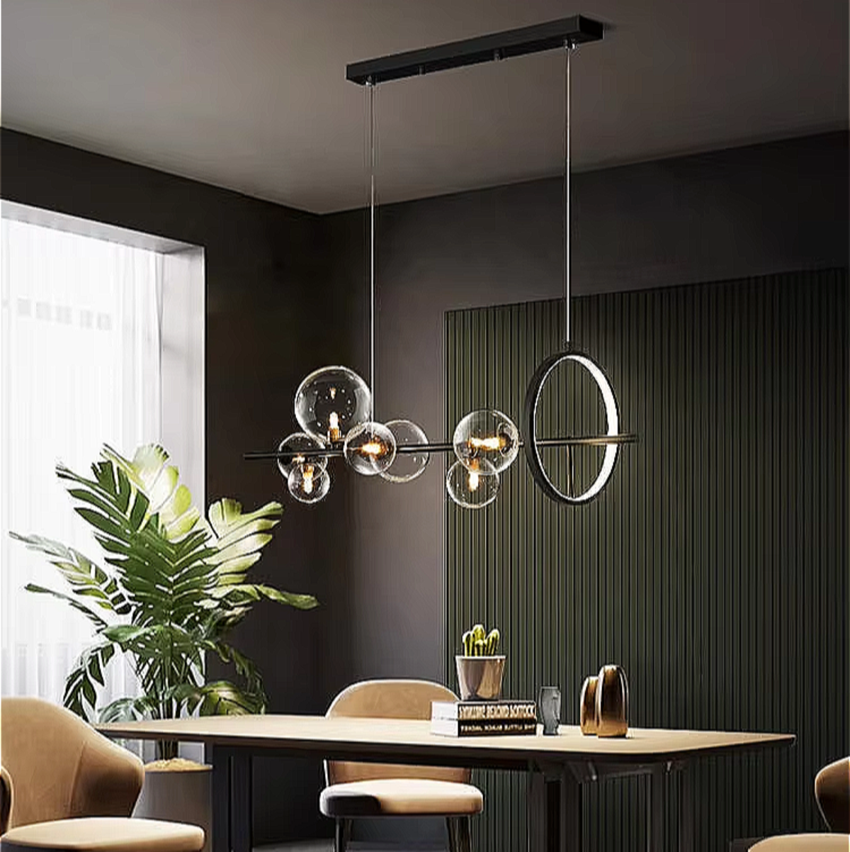 Luxury dining-kitchen space featuring a TRUNKO NOIR LED chandelier — clear glass globes on a black iron beam floating above elegant marble surfaces.

