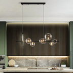 LINKORI TRUNKO NOIR black glass chandelier installed above a luxury kitchen island, featuring asymmetrical glass globes and matte black linear frame.