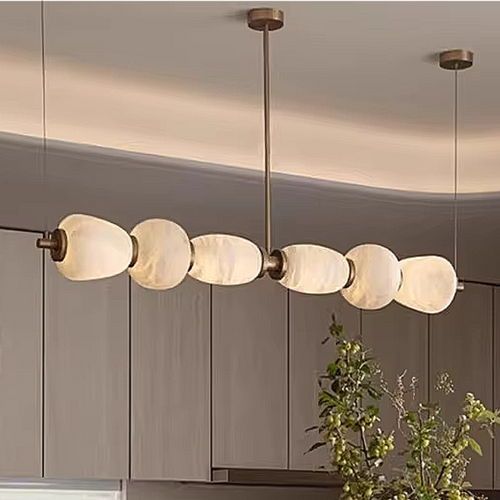 Modern alabaster pebble linear chandelier above kitchen island with warm ambient lighting in luxury minimalist dining interior – LINKORI MARSH MARBLE