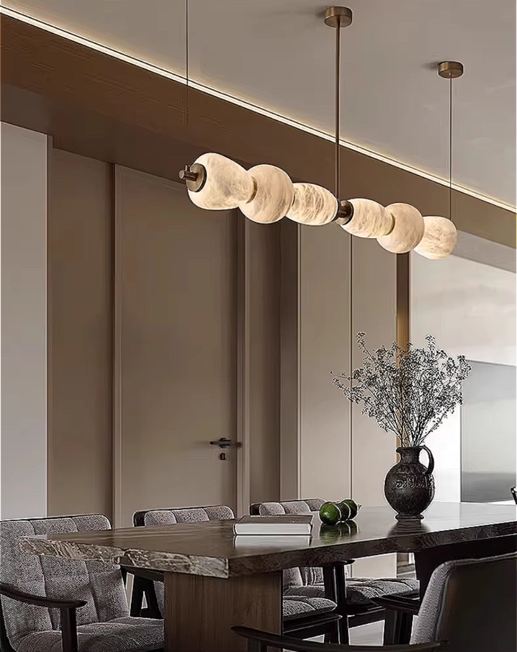 Neutral modern dining room interior with alabaster linear chandelier, Spanish stone pendant light and copper frame – LINKORI