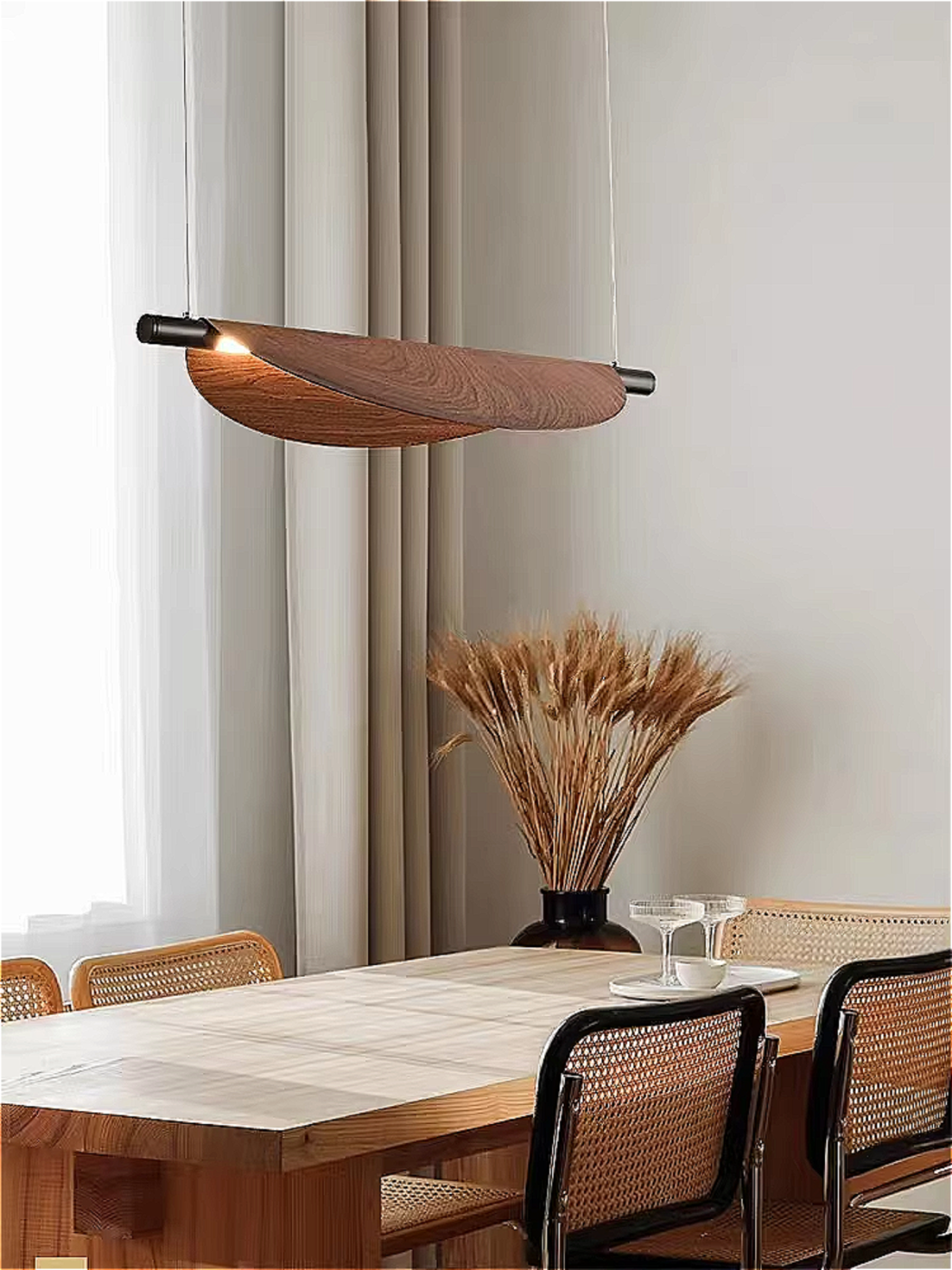 Curved wood pendant light casting serene light over a modern wood- coffee table
