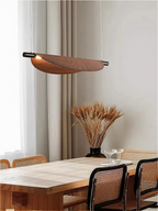 Curved wood pendant light casting serene light over a modern wood- coffee table
