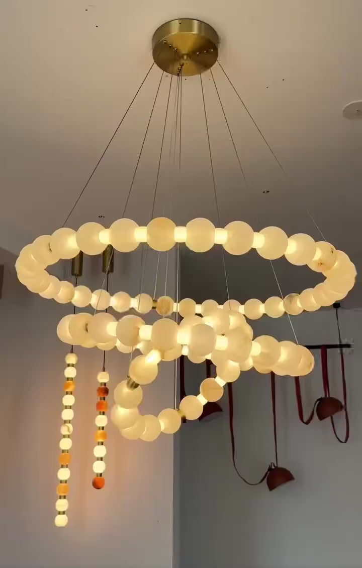 Alabaster chandelier for high ceiling living room with 3 tier beaded ring design, natural Spanish stone beads, and luxury modern lighting by LINKORI AURELIA