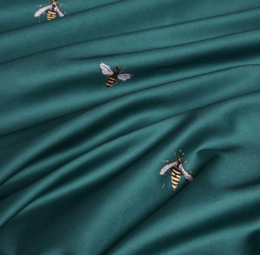 Detailed view of whimsical bee embroidery stitched onto rich green duvet cover – LINKORI H. Bee design highlight