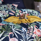 Detail view of flamingo and palm leaf print across duvet cover and pillows — rich tropical design on silky navy Egyptian cotton.
