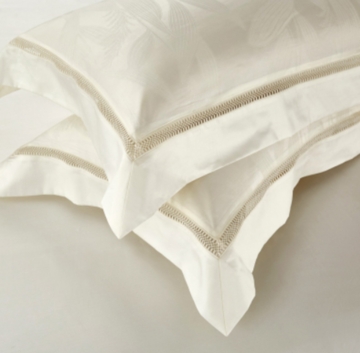 Ivory pillowcases displayed on flat sheet, showing refined tone-on-tone botanical patterns — LINKORI Lilela minimalist bedding.