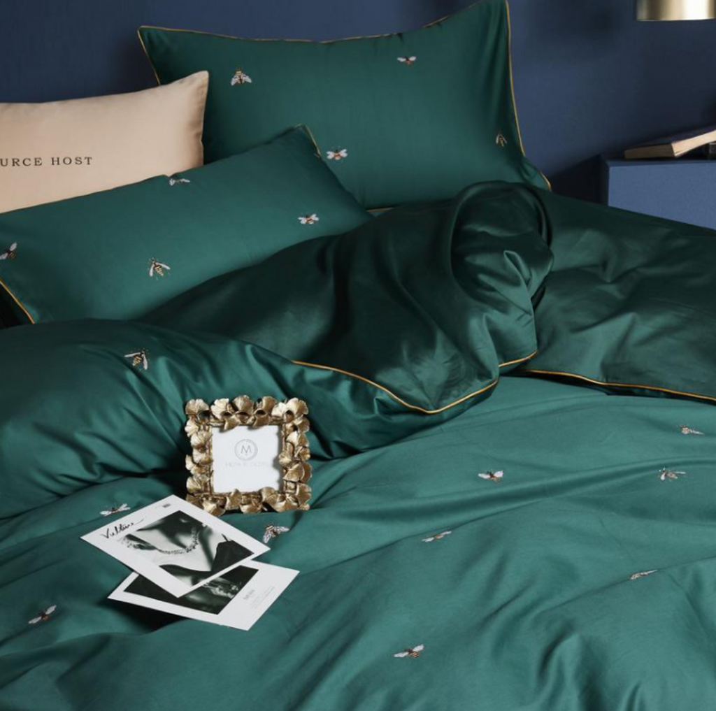 Close-up of bee embroidery detail on deep green Egyptian cotton duvet and pillowcase – soft, breathable luxury