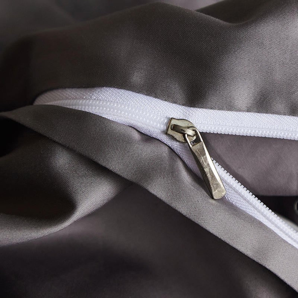  Close-up of concealed zipper detail on dark flat sheet — minimal and functional with refined stitching.
