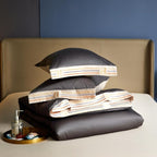 folded grey satin-finish duvet cover and two pillows on cream-gold Egyptian cotton flat sheet coordinated luxury bedding styling | LINKORI Grey Satin