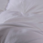 Close-up of quilted white goose down comforter surface – premium cotton shell, soft texture, and luxurious stitching details