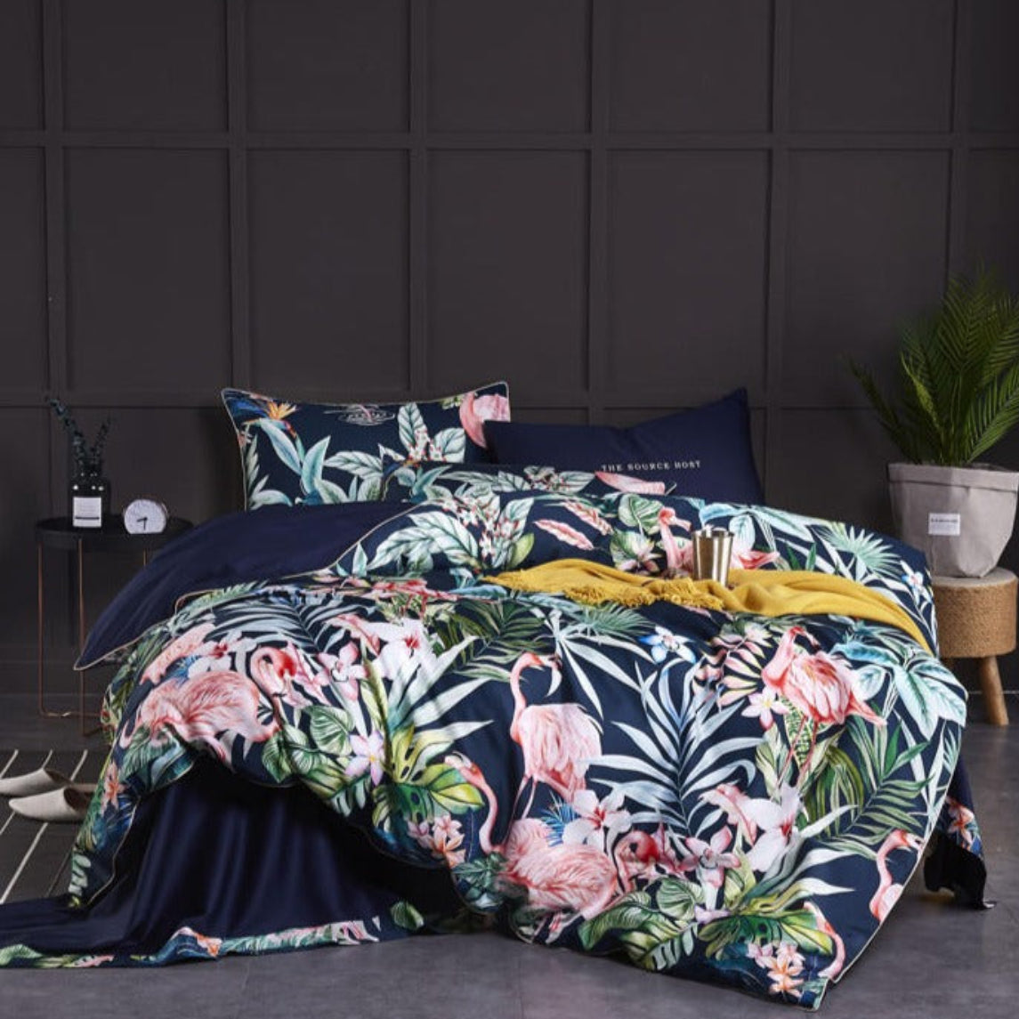 Full view of LINKORI Hawild tropical duvet cover set featuring pink flamingos and jungle leaves on a navy base — styled in a bold, bohemian bedroom.