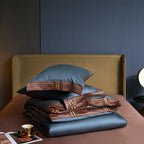 Blue Egyptian cotton duvet and pillow folded neatly on brown satin flat sheet – luxury bedding styling in modern interiors