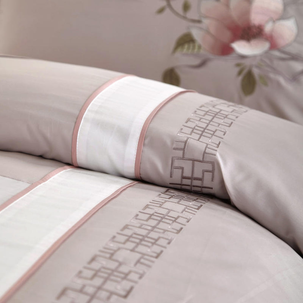 Close-up of the Floraline duvet cover's graceful pink blossom print, showcasing the delicate floral motif.