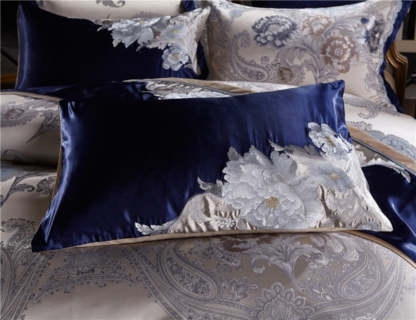 Close-up of embroidered pillow from LINKORI Stopiak set featuring elegant floral detailing in silver and blue