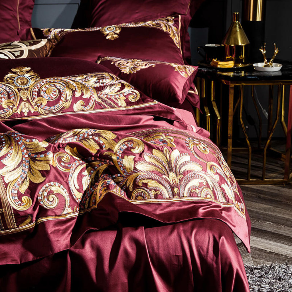 Close-up of duvet and pillows from LINKORI Zutapera – golden baroque embroidery on deep red Egyptian cotton