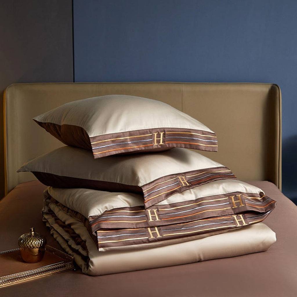 Beige duvet cover folded on top of brown flat sheet with matching pillows – LINKORI satin bedding styling