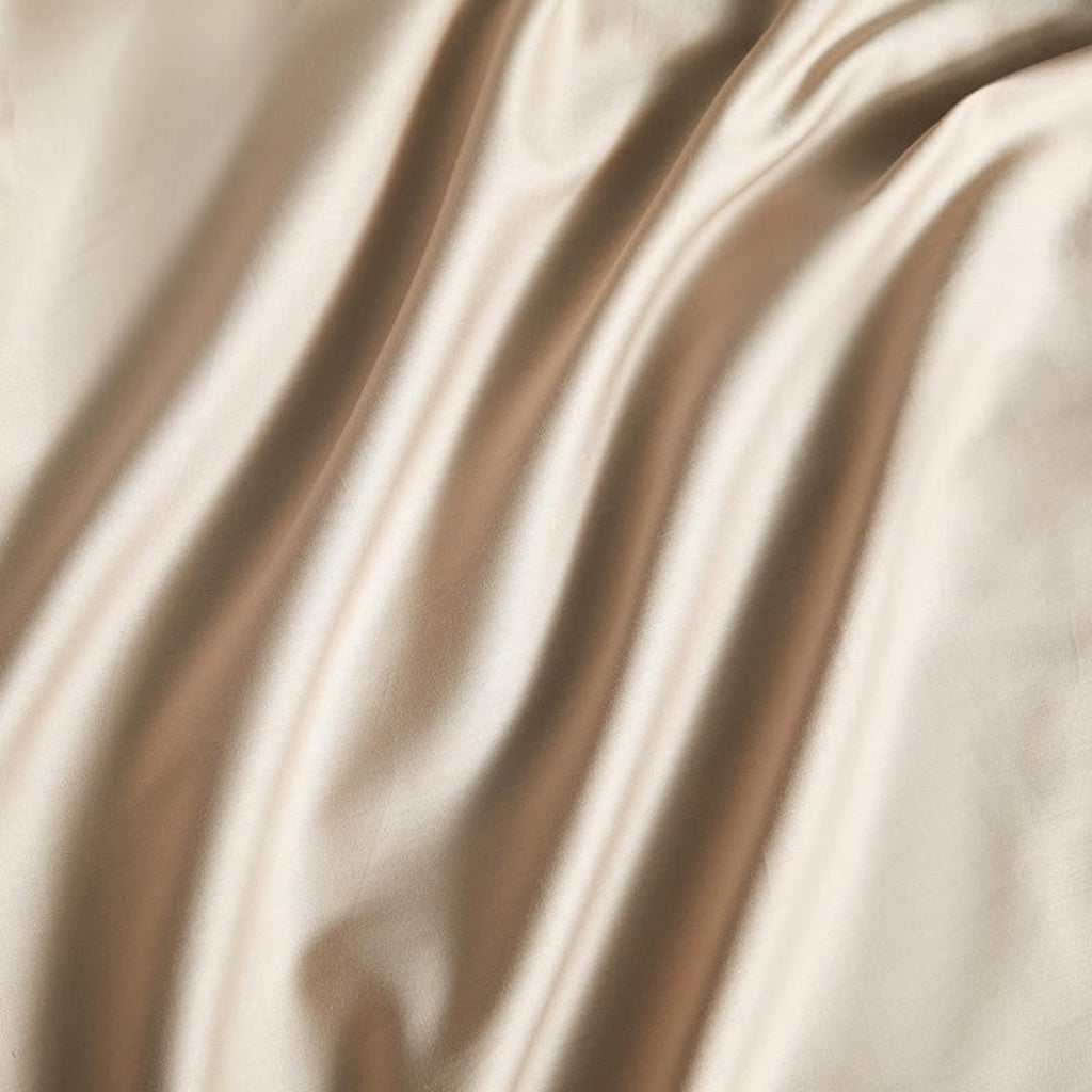 Close-up of silky smooth beige satin duvet texture – 600 thread count Egyptian cotton fabric