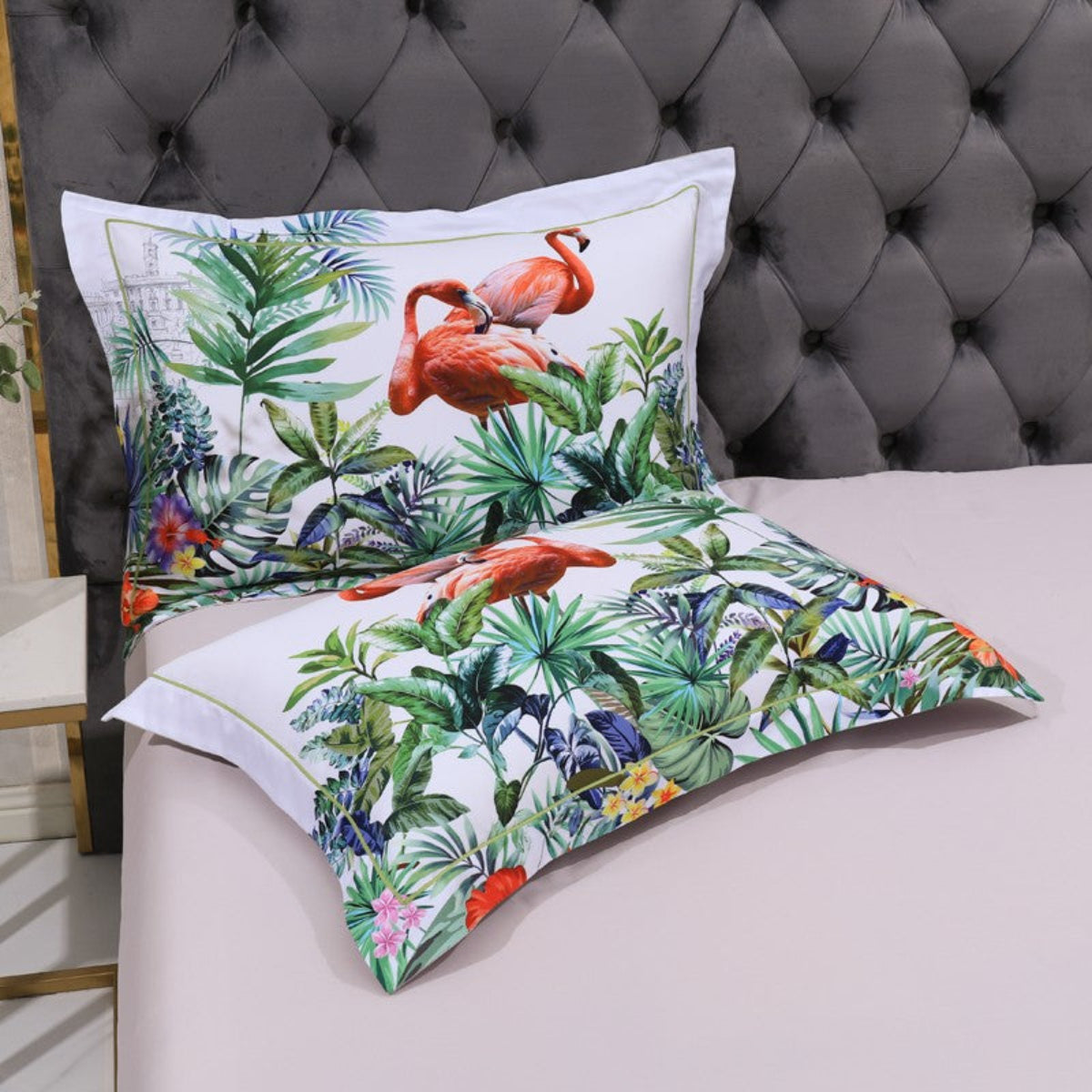 Two jungle-print pillows resting on smooth beige flat sheet – a contrast of vivid nature and calm base in the Wilife set