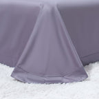 Detail of hemmed edge on lavender flat sheet, part of the 4-piece LINKORI G. The Flowers bedding set