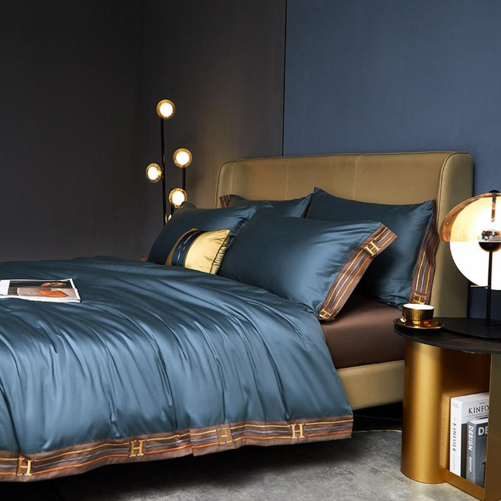 Blue duvet, brown embroidered trim, and matching brown flat sheet and pillows in modern interiors.