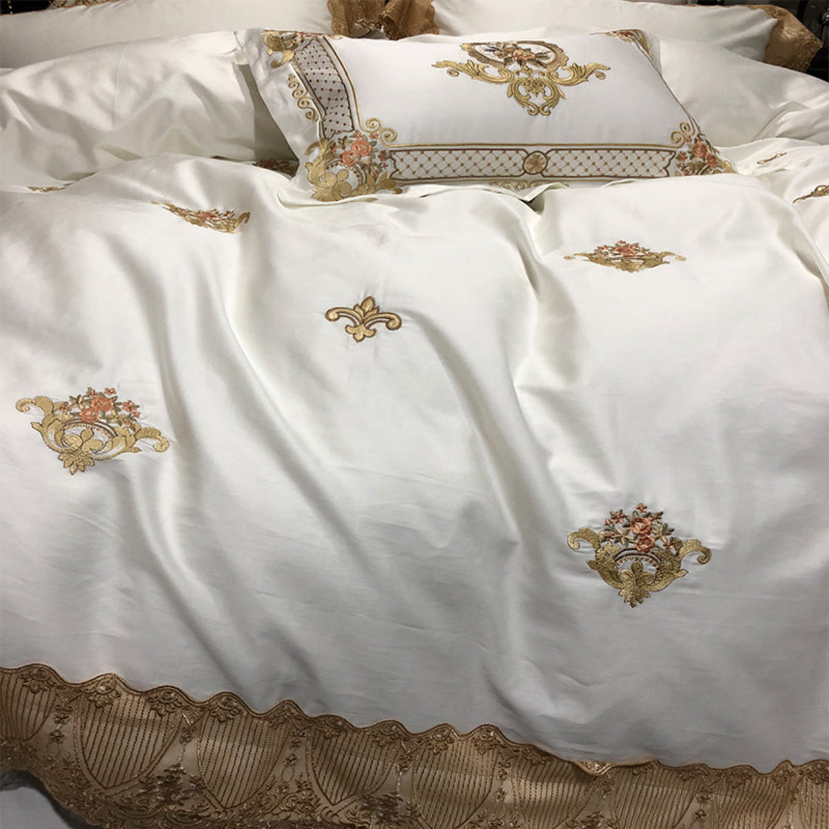 Detailed close-up of gold embroidered crest motif on LINKORI Stonge Royal duvet cover in white Egyptian cotton