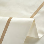 Detailed shot of the beige duvet cover’s embroidered golden trim, emphasizing its elegant finishing and hotel-luxury appeal.