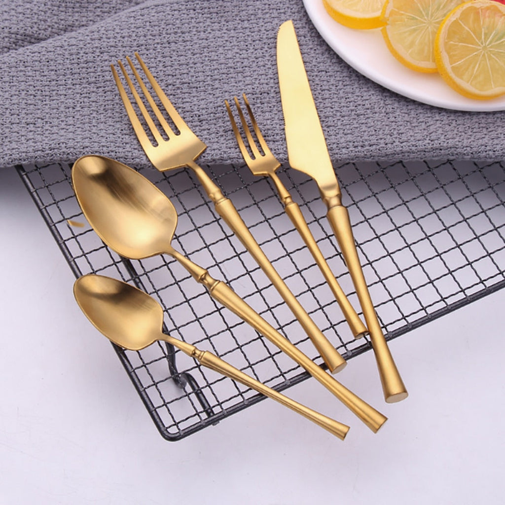 Top-down view of minimalist gold knife, fork, spoon set with ergonomic design. Perfect for chic table styling content.