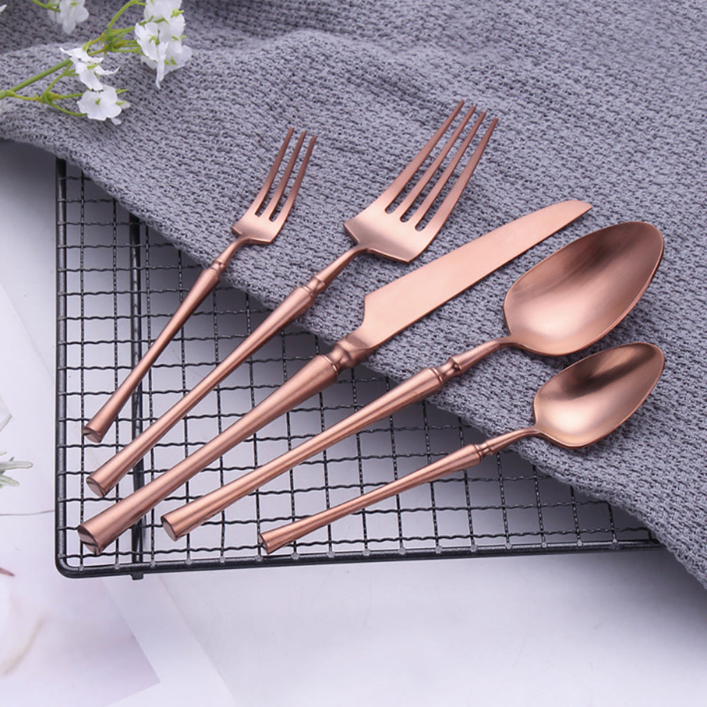 30-piece rose gold flatware set displayed on cream linen — modern stainless steel cutlery for elegant dining tables