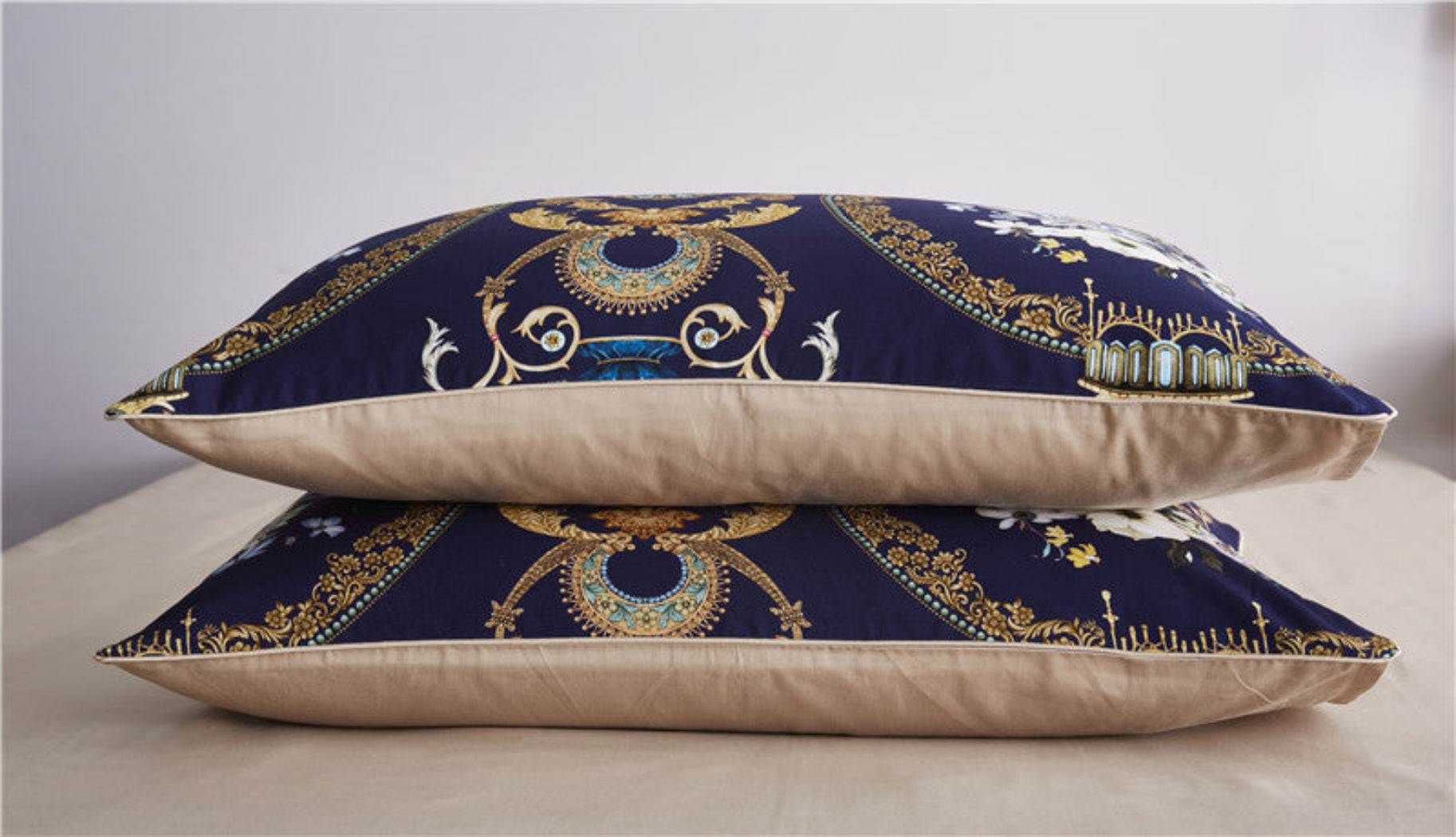 Two royal print pillows on beige cotton sheet – navy-gold floral pattern styled for classic bedrooms | LINKORI Doquar