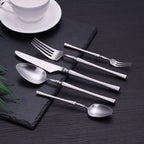 Minimalist silver flatware set styled on textured black surface — modern dining table cutlery for luxury entertaining, LINKORI Lilla Silver top view.
