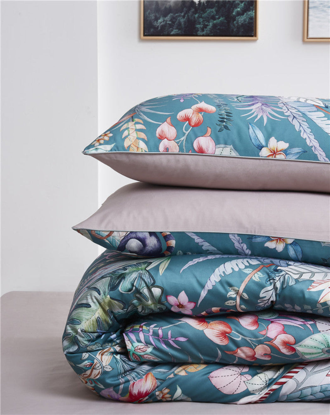 Folded tropical duvet cover and two matching pillows on beige Egyptian cotton flat sheet – jungle-inspired print with coral and monkeys | LINKORI Blumer