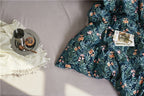 Close-up of botanical floral print on duvet cover – soft blush flowers and greenery over teal cotton | LINKORI On the Grass
