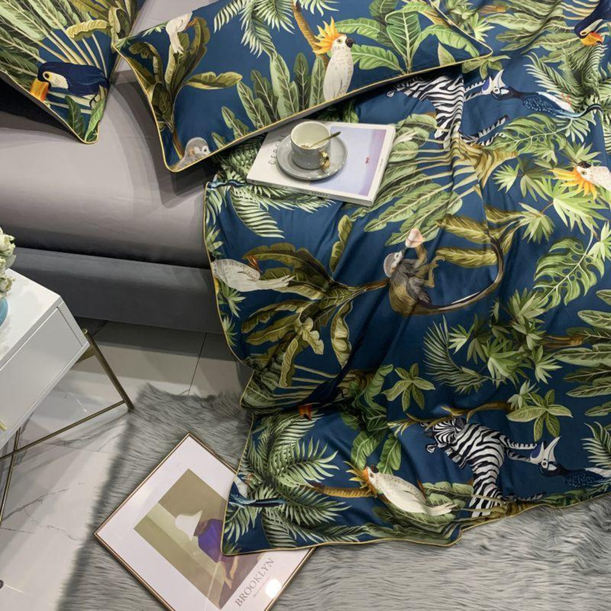 Close-up of pillowcases and duvet cover detailing exotic toucans, palm leaves, and vibrant jungle patterns.