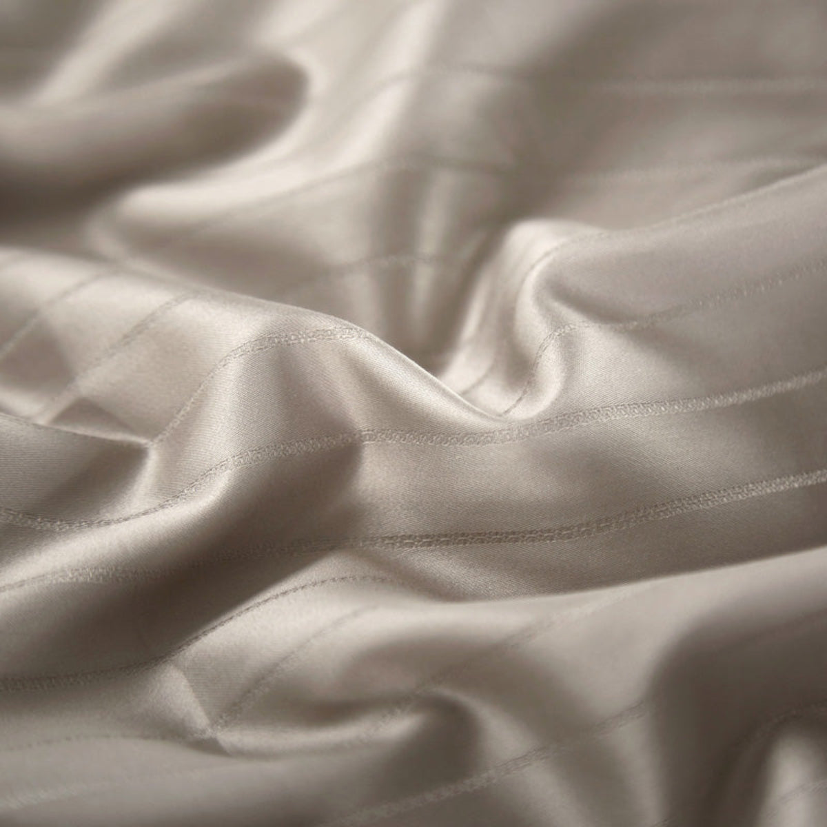 Macro shot of soft 800 thread count Egyptian cotton fabric with smooth weave texture in satin champagne finish.
